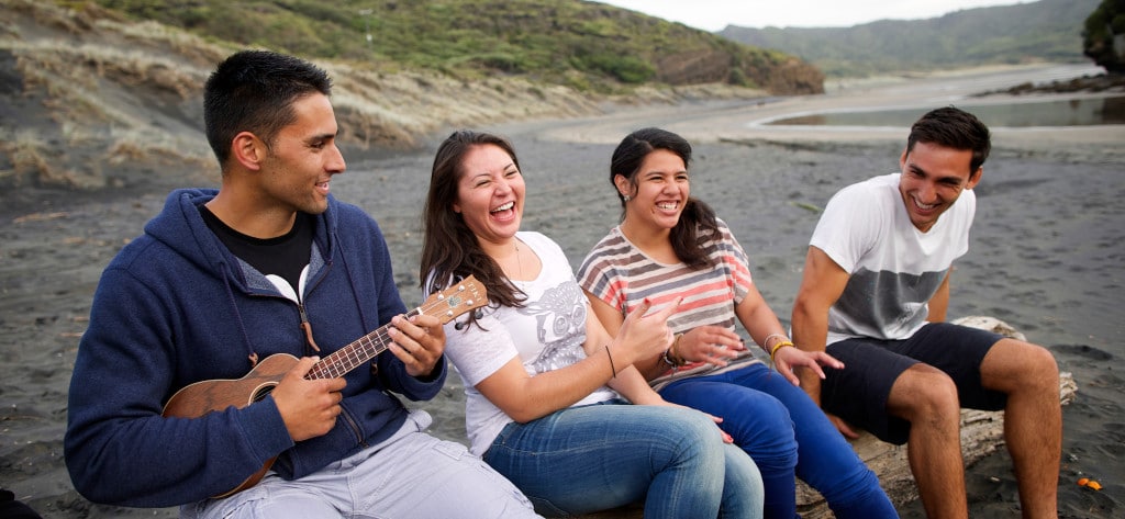 young people enjoy music on the beach